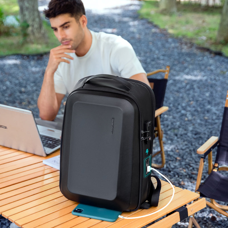 Black hardshell GuardianShell anti-theft backpack with charging port, outdoor workspace, MARKRYDEN Global