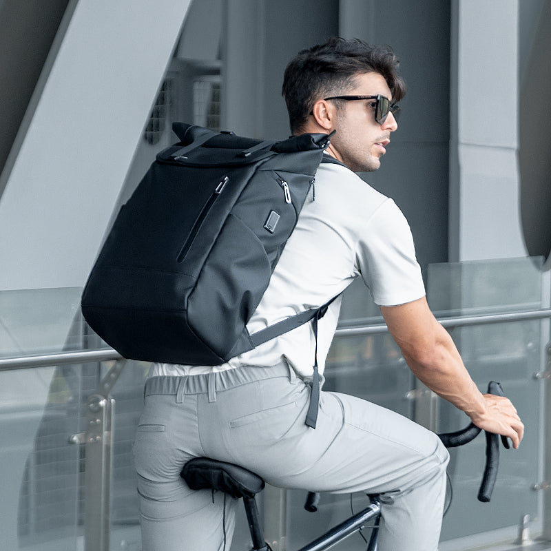 Black Switch 29L daily business multifunctional backpack on cyclist near modern building