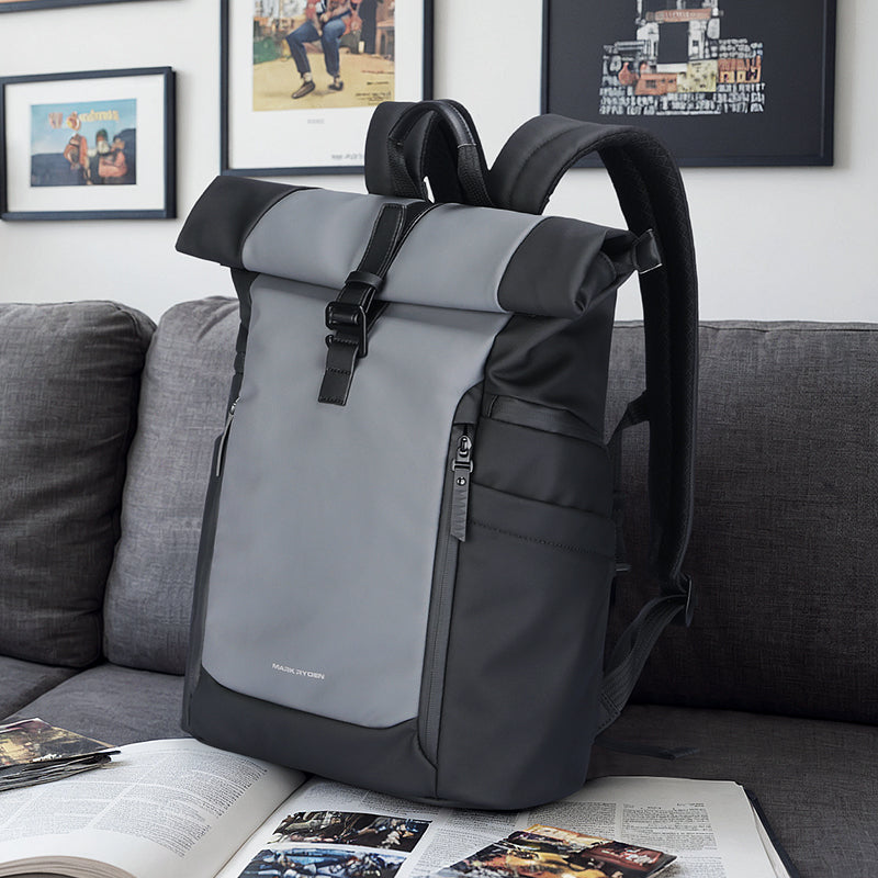 Mark Ryden DynaPack gray/black laptop bag with roll-top closure on couch
