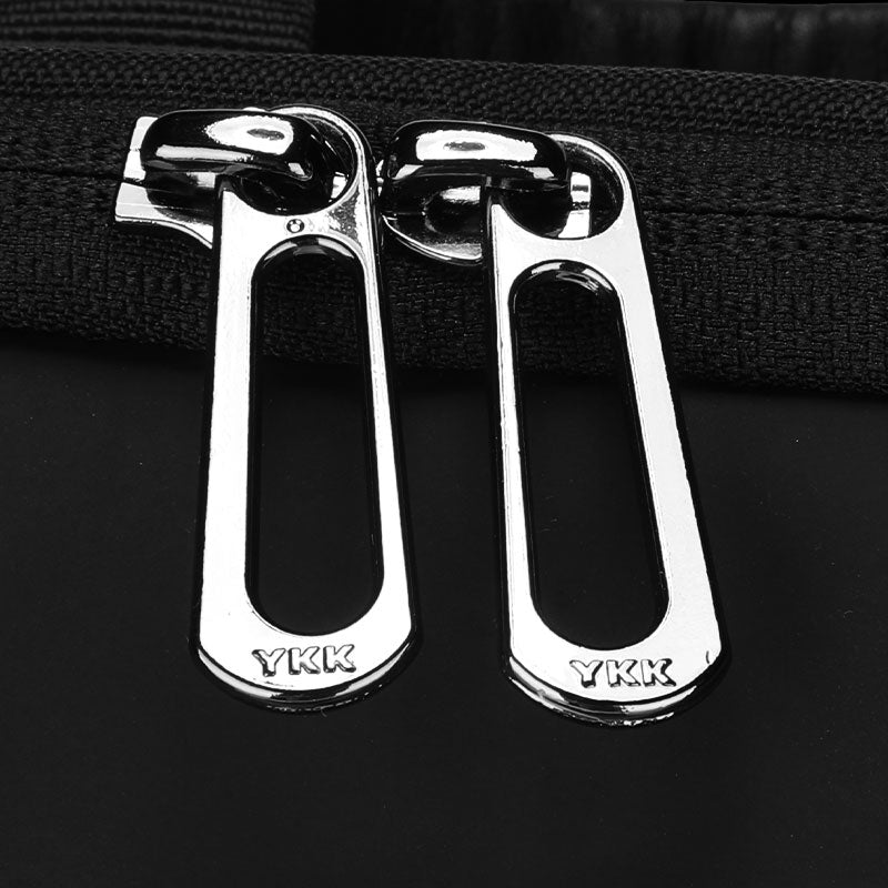 Shiny silver YKK zipper pulls on black travel bag - Mark Ryden water-repellent companion