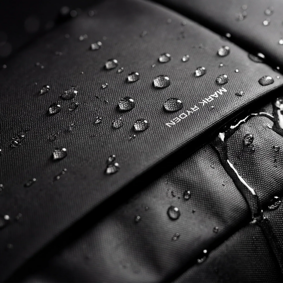 Mark Ryden splash-proof backpack with water droplets showcasing durability