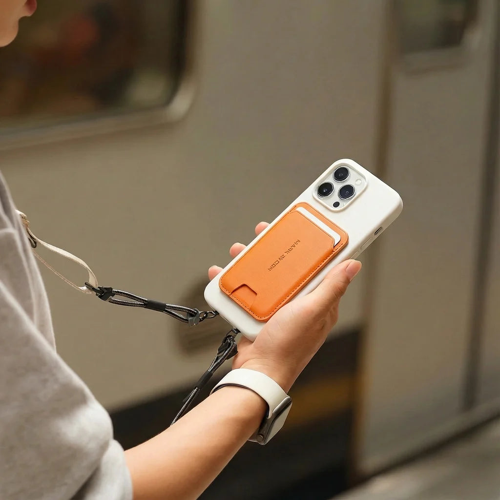 Mark Ryden Global's orange MagSafe foldable card holder wallet on white phone in transit