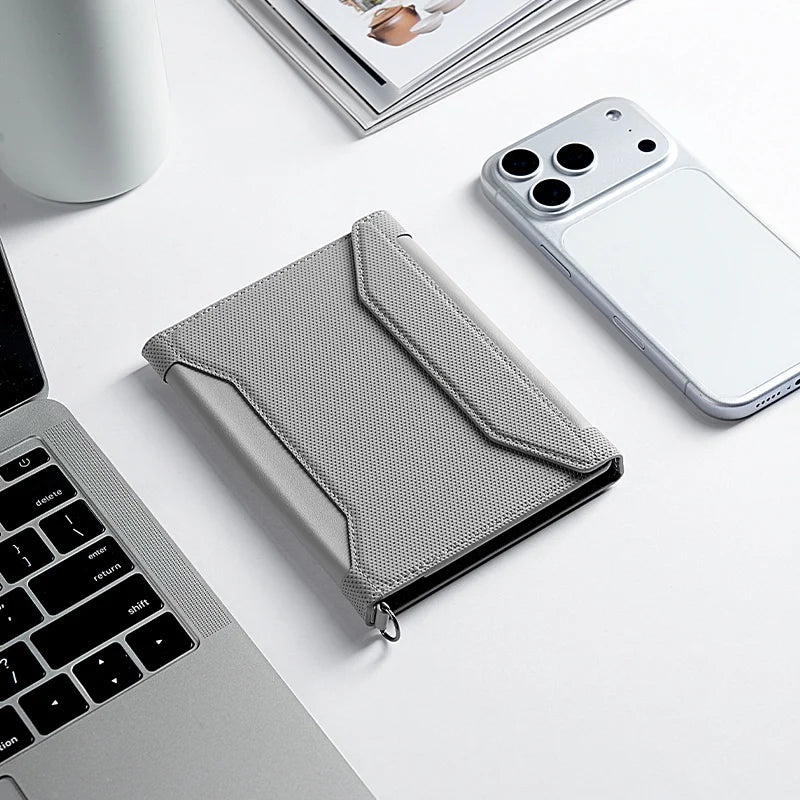 MarkRyden Global's gray instant-access crossbody travel card wallet, modern design, near phone & laptop