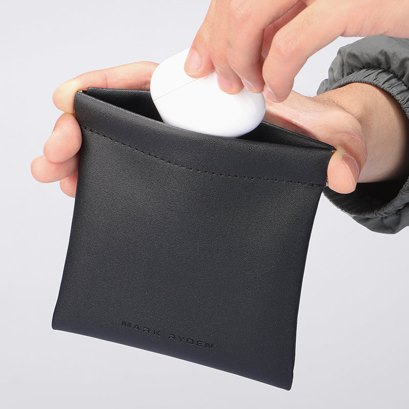 Mark Ryden black leather coin pouch securing white item - modern travel accessory